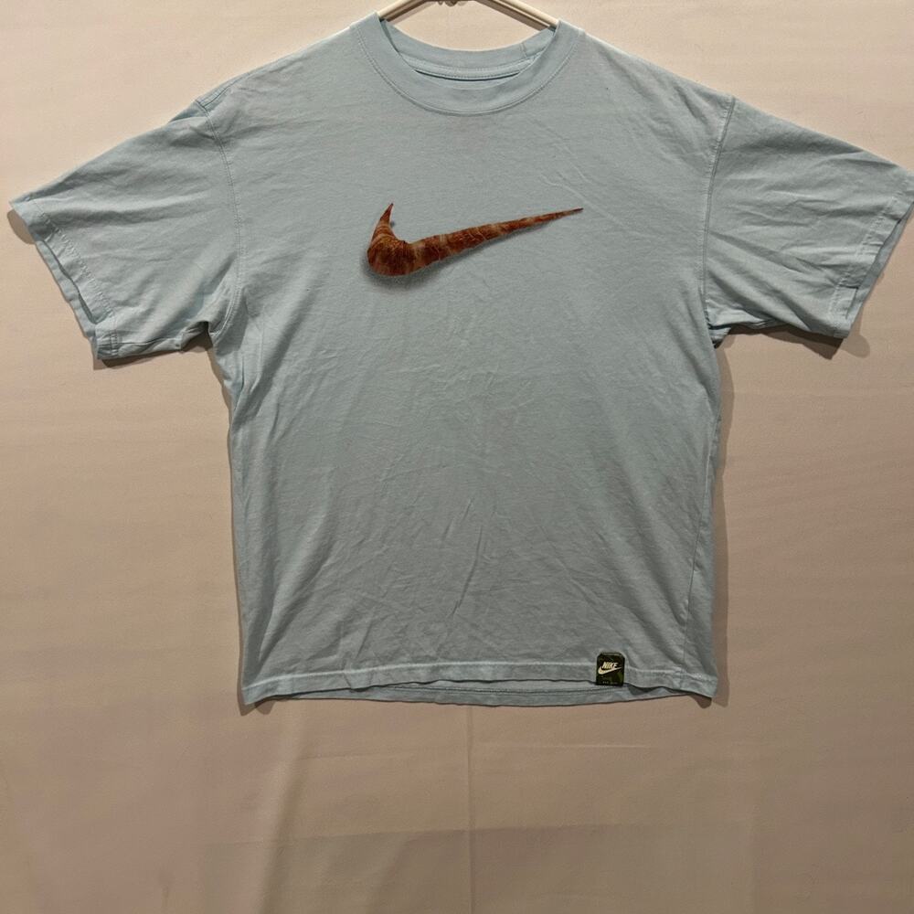 The Nike Tee, size: M. Loose Fit. Color: Light Blue. Graphic: Croissant